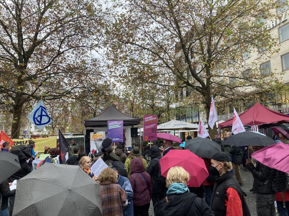 Demo „Jetzt glangt’s“, Blick auf die Bühne zwischen aufgespannten Regenschirmen