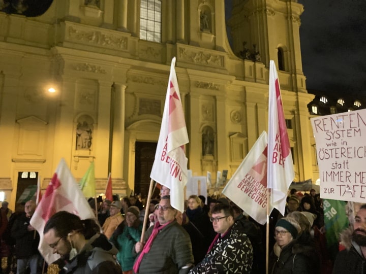 Demonstrierende der KAB mit Fahnen vor der Kulisse der Theatinerkirche.