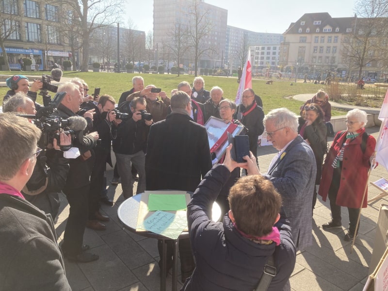 KAB-Bundesvorsitzende Beate Schwittay übergibt ein gerahmtes Bild der gesamten Picknickdecke an Bodo Ramelow.